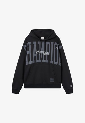 Czarna bluza z kapturem z dużym szarym napisem „CHAMPION” oraz logo. Posiada kieszeń typu kangur, regulowany kaptur, ściągacze na rękawach i u dołu. Widoczna metka rozmiaru.