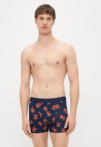 Cuecas boxer azul-marinho com padrão repetido de homens de gengibre em laranja e vermelho. Apresentam uma faixa escura com a inscrição "HAPPY". Material de algodão, design ajustado.