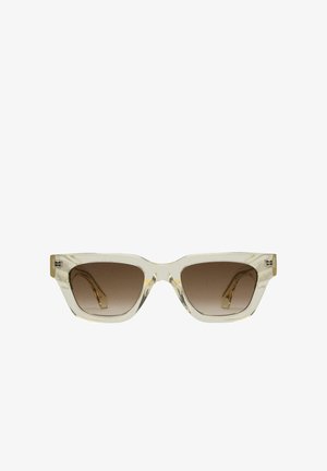 Duidelijke zonnebril met een geometrische cat-eye vorm; bruine verlooplenzen; slank transparant montuur; gouden accenten op de veren.