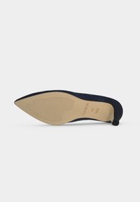 Chaussure à talon haut bleu marine à bout pointu, posée sur le côté, affichant une semelle beige de taille 4½ et la marque « Gabor ».