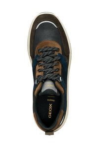 Zapatilla de hombre que combina cuero negro y ante marrón, con acentos en azul marino, cordones moteados y una suela acolchada.