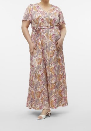 Kvinde iført en V-hals, kortærmet kjole i ankel-længde med et pink, orange og lilla blomster paisley mønster og bundet taljebælte.