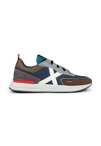 Zapatillas para hombre que combinan materiales en azul, gris, marrón y blanco. El diseño incluye un patrón distintivo en forma de X blanca y acentos en rojo.