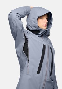 Light gray waterproof jacket with black accents, zippered pockets, and hood. Features a sleek, structured design and soft texture.
