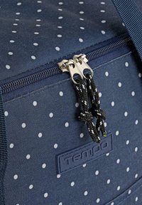 Bolsa de color azul marino con cremallera y lunares blancos. Presenta una tela texturada, cremallera de metal y un tirador anudado en blanco y negro para un fácil acceso.
