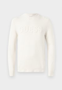 Suéter blanco hecho de un suave tejido de punto, con un cuello redondo y la palabra "GUESS" en relieve en la parte delantera. Puños y dobladillo de canalé.