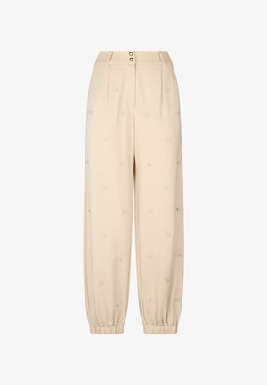 Pantaloni beige con una vestibilità comoda, polsini elasticizzati, vita plissettata e piccoli motivi ricamati distribuiti su tutta la superficie. Due bottoni frontali in vita.