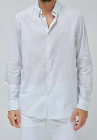 Camicia a maniche lunghe a righe blu chiaro e bianche, in tessuto di cotone, con colletto abbottonato, orlo arrotondato e polsini abbottonati.