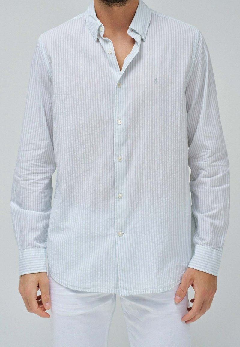 Camicia a maniche lunghe a righe blu chiaro e bianche, in tessuto di cotone, con colletto abbottonato, orlo arrotondato e polsini abbottonati.