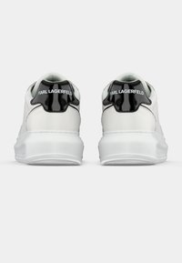 Λευκά sneakers με λείο δερμάτινο φινίρισμα, διαθέτουν μαύρη πατενταρισμένη πίσω γλώσσα και την επωνυμία "KARL LAGERFELD" στο πίσω μέρος. Ελαστική σόλα.