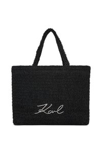 Fekete szövött kézitáska texturált felülettel, rövid fogantyúkkal és ezüst "Karl" logóval az elején.