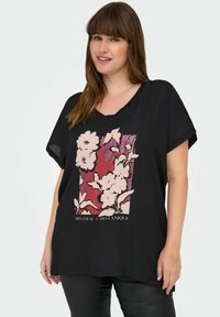 Crna bluzica kratkih rukava s cvjetnim grafičkim uzorkom u nježno ružičastoj i crvenoj boji, s natpisom "ABSTRACT BOTANIQUE" na dnu.