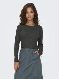 Langärmliges dunkelgraues Oberteil mit rundem Ausschnitt, kombiniert mit einem knielangen blauen Rock mit elastischem Bund und Taschen.