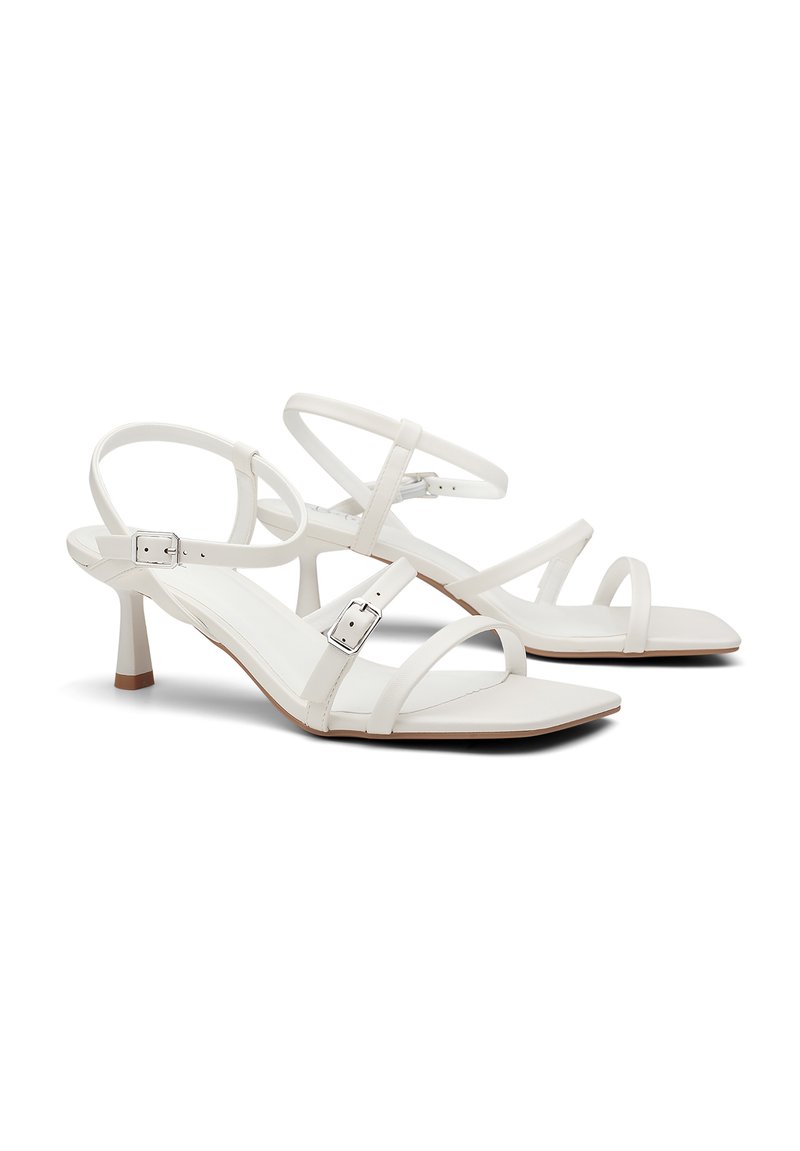 Sandales à talons blancs en cuir lisse, avec des fines lanières, un design à bout carré, une boucle réglable à la cheville et un talon effilé.