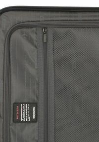 Gray travel bag interior featuring a zipper compartment, mesh pocket, and a label with care instructions and brand name, "Wittchen."