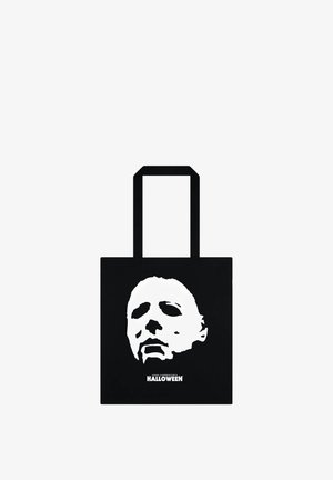 Černá taška přes rameno s bílou grafikou obličeje a textem "JOHN CARPENTER'S HALLOWEEN" dole. Měkký materiál, obdélníkový tvar, dvě ucha.