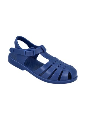 Sandalia de plástico azul con diseño de punta abierta, correa ajustable y secciones recortadas en la parte superior para ventilación. Suela texturizada antideslizante.