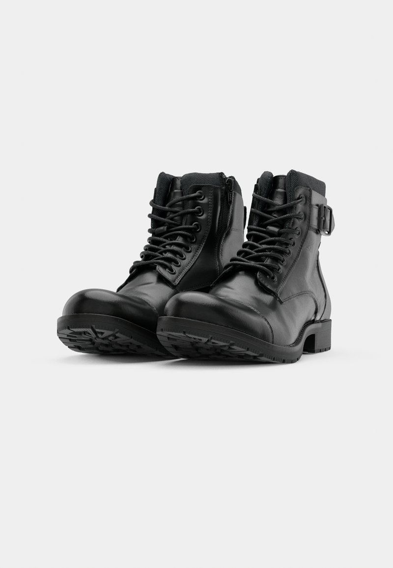 Stivaletti neri in pelle con lacci davanti, zip laterale e dettaglio della fibbia regolabile. Suole in gomma testurizzata per una migliore aderenza.