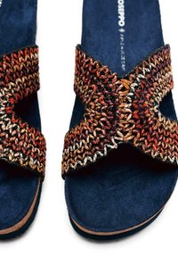 Tongs bleu marine avec une large sangle tissée dans des tons terreux. La sangle présente un design croisé avec différentes textures et couleurs.