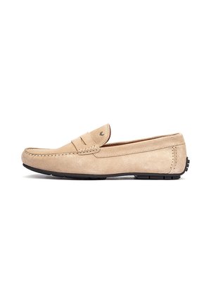 Beiger Wildleder-Slipper mit Mokassinstich und schwarzer Gummisohle, Seitenansicht auf weißem Hintergrund.