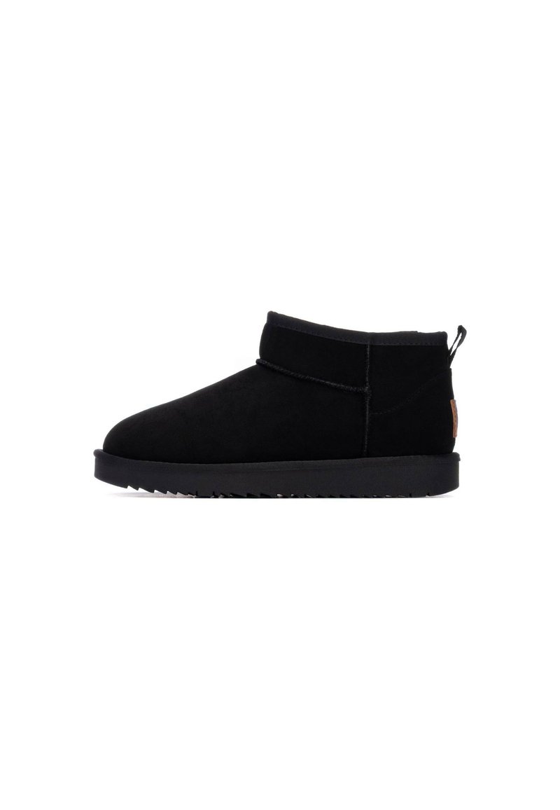 Botas de tobillo de ante negro con punta redondeada, banda elástica y suela de goma negra texturizada. Destaca por su tirador en el talón para facilitar el calzado.