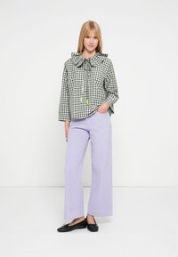 Πράσινο και λευκό καρό κοντό μπλουζάκι με μεγάλο γιακά και κορδόνι στη μέση. Συνδυασμένο με ανοιχτό μοβ παντελόνι φαρδιάς γραμμής και μαύρα πλατφόρμα παπούτσια.