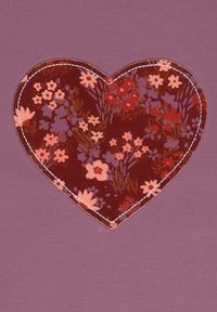 Lila Stoff mit einem genähten Herz-Patch, das ein bordeauxfarbenes Blumenmuster zeigt, einschließlich rosa und lavendelfarbenen Blumen.