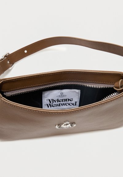 Barna bőr táska állítható pánttal, félig nyitott cipzárral, amely fekete belsőt és fehér Vivienne Westwood címkét mutat belül.