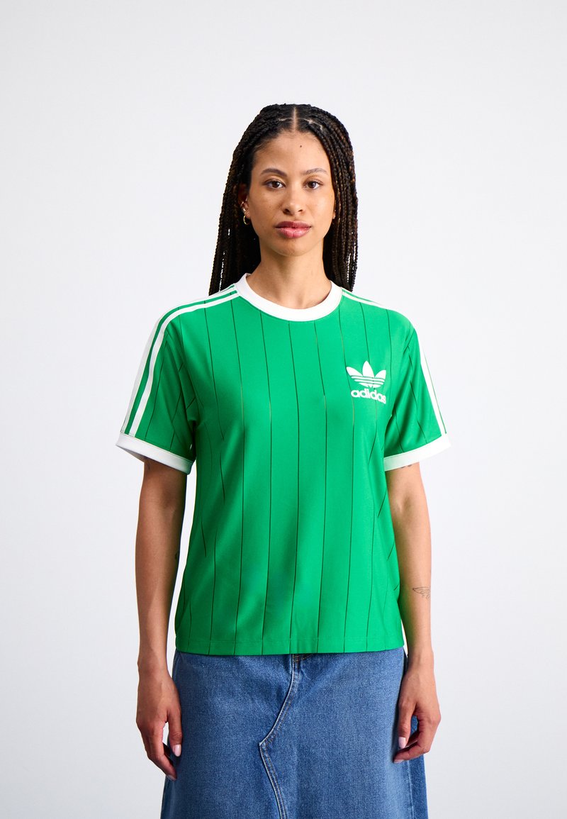 Camiseta verde de adidas con cuello y puños acanalados en blanco, con rayas verticales blancas y un logo en el lado izquierdo del pecho.
