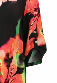 Fließende Bluse mit schwarzem Grund, die lebhafte Blumend patterns in Orange und Grün aufweist, runde schwarze Knöpfe an den Ärmeln hat und aus leichtem Stoff gefertigt ist.
