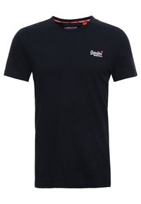 Camiseta de algodón negra con cuello redondo, que presenta un pequeño logo bordado en blanco en la parte izquierda del pecho. Mangas cortas, diseño sencillo.
