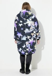 Lång, huva jacka med en svart bas och ett färgglatt stjärnmönster i lila, gult och vitt. Elastisk nederkant och ärmar.