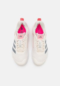 Lettare atletiske sko med en mesh-overdel i off-white, grå striber og pink detaljer. Funktionen inkluderer en polstret krave og en struktureret sål.