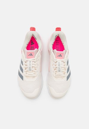 Lettare atletiske sko med en mesh-overdel i off-white, grå striber og pink detaljer. Funktionen inkluderer en polstret krave og en struktureret sål.