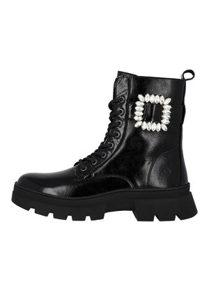 Bottes de combat en cuir verni noir à lacets avec une semelle épaisse, présentant un détail de boucle en strass décoratifs sur le côté.