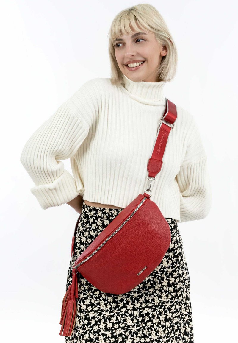 Borsa a spalla in pelle rossa con design curvo, zip in argento e superficie testurizzata. Presenta un accento a frange e una tracolla regolabile.