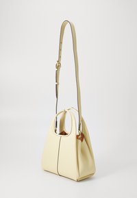 Yellow leather handbag with a soft, structured shape. Features dual rounded handles and a long adjustable strap with brass hardware accents.