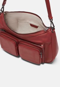 Borsa a mano in pelle rossa con una texture morbida, dotata di un compartimento principale con zip e due tasche anteriori con zip per ulteriore spazio di stoccaggio.