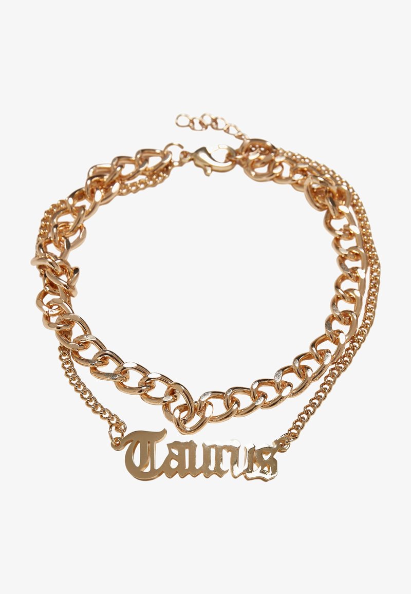 Gold-tone chain necklace with chunky links and a smaller chain. Features "Taurus" pendant in decorative script. Polished finish.