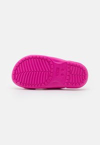 Suola in gomma rosa con un motivo testurizzato, caratterizzata da scanalature e protuberanze per una migliore aderenza. Nome del marchio "Crocs" impresso.