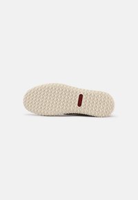 Suola della scarpa con un motivo esagonale beige e un logo rettangolare rosso con la scritta "rieker" centrato nella parte centrale.
