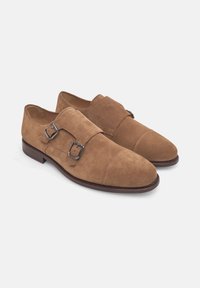 Braune Wildleder-Doppel-Monk-Schnallen Schuhe mit silbernen Schnallen, runder Zehenform und einer kontrastierenden dunkelbraunen Ledersohle.