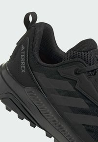Zwarte Adidas Terrex trail hardloopschoen met mesh-bovenwerk, gestructureerde zool en trekkoordje bij de hiel.