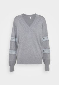 Pull gris à manches longues avec col en V, bandes de dentelle bleu clair sur le haut des bras, poignets et ourlet côtelés.