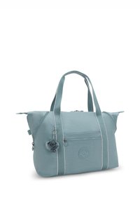 Light blue fabric tote bag with dual handles, front zip pocket, and a round logo. Features a furry charm attached to a zipper.