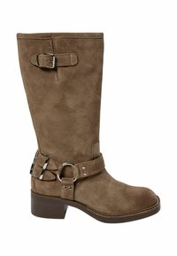 Brūni zamšādi ceļa augstuma zābaki ar noapaļotu purngalu, zemu kvadrātveida papēdi un divām regulējamām sprādzēm sānos. Akcentēti ar metālisku aparatūru.