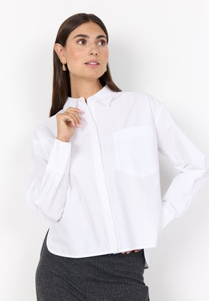 White button-up shirt with a collar, long sleeves, and a chest pocket. Fabric appears smooth with a structured fit and minimalistic design.