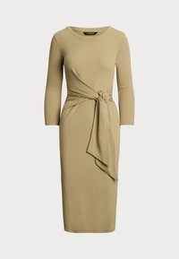Robe à manches longues et longueur genoux en tissu beige doux. Présente un détail de taille nouée et un col rond avec une silhouette ajustée.
