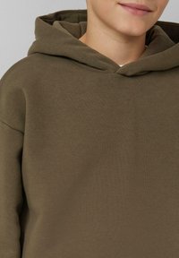 Khaki groene hoodie met een zachte textuur, voorzien van een trekkoordkap en een relaxed fit. Zichtbare stikseldetails bij de halslijn.