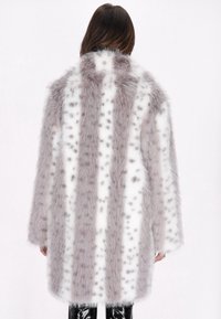 Faux fur frakke i hvid og lysegrå med et stribet mønster. Har en løs pasform og en mellemlang design med en blød, tekstureret overflade.